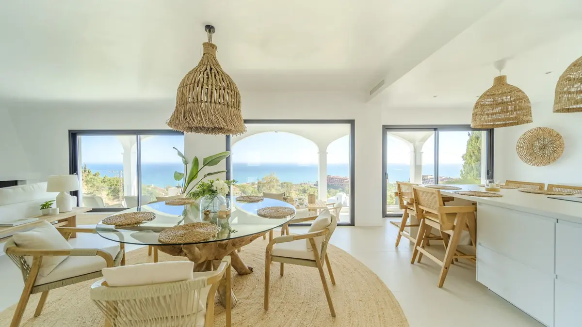 Open-plan living and dining room in Villa Zentosa with rattan pendants and sea views