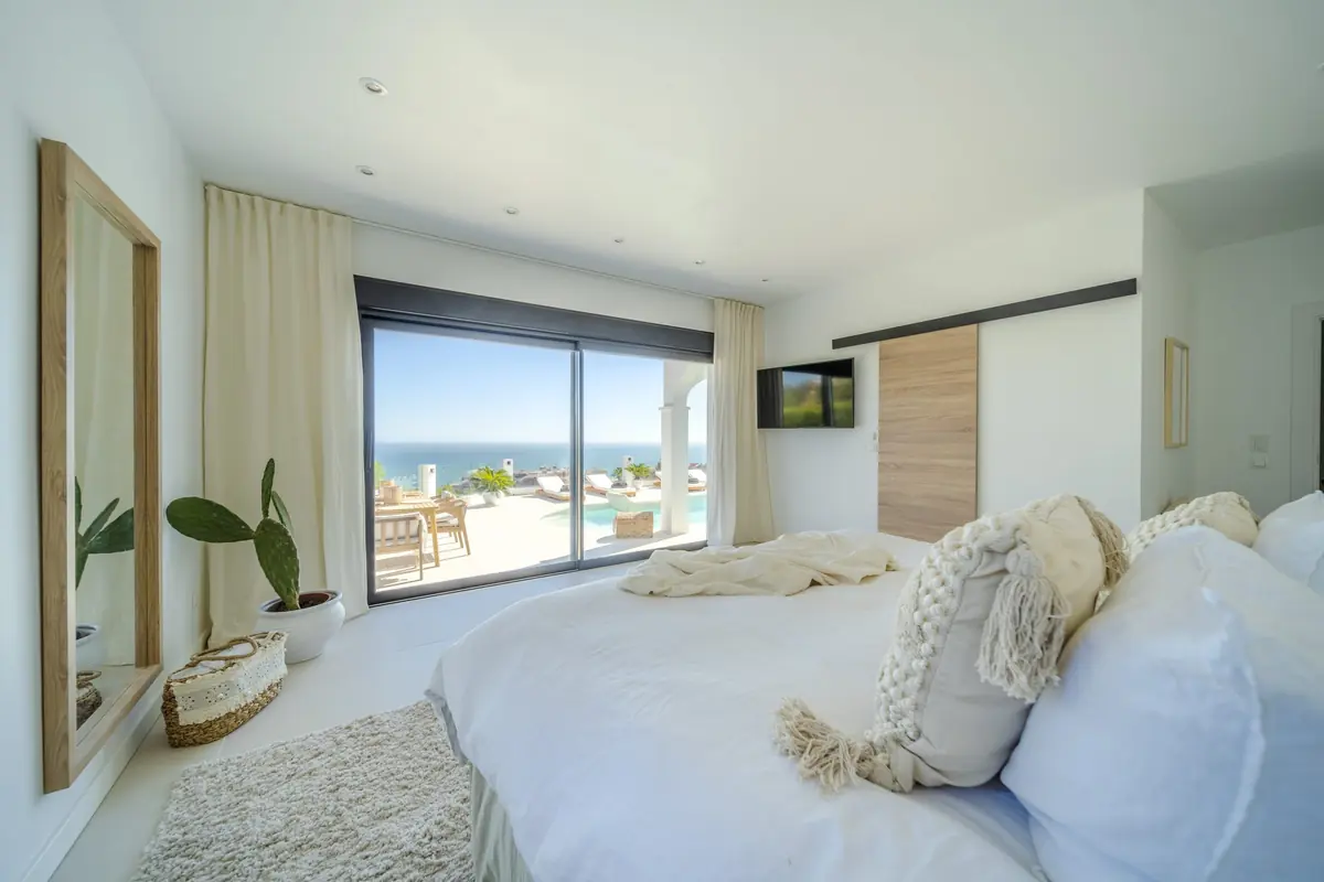 Main bedroom of Villa Zentosa with linen bedding and a sea view