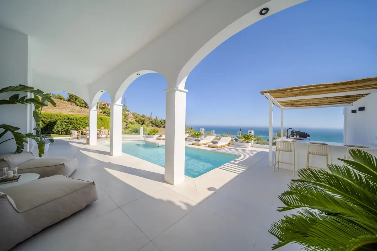 Pool terrace and outdoor kitchen under a reed pergola at Villa Zentosa
